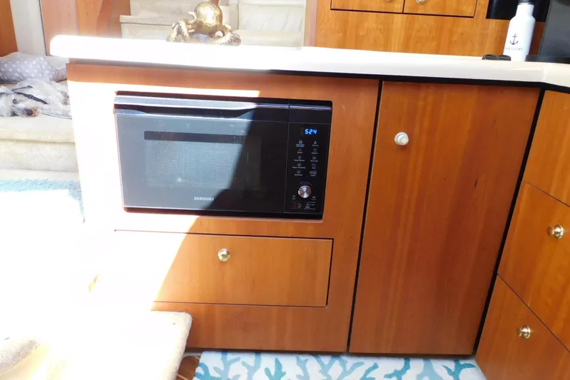 How Lucky Yacht Photos Pics 2003 Cruisers Yachts 3750 Motoryacht kitchen with Samsung microwave and wooden cabinetry.