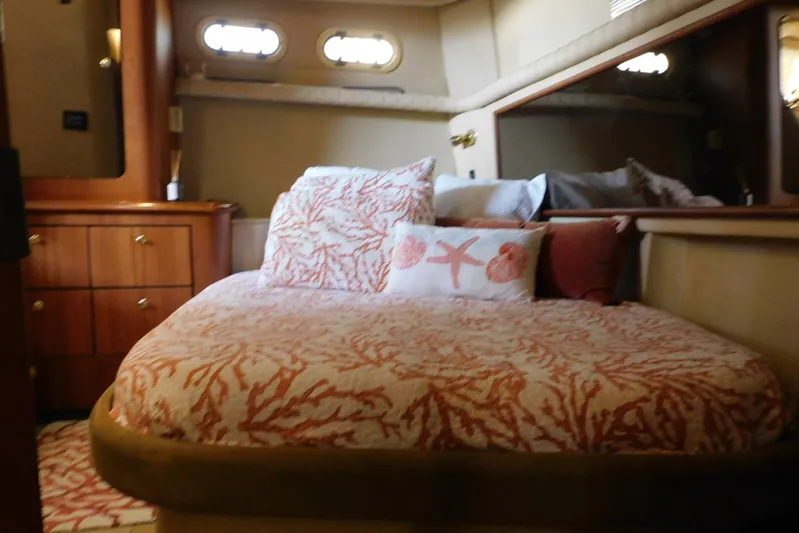 How Lucky Yacht Photos Pics Luxurious bedroom interior of 2003 Cruisers Yachts 3750 Motoryacht with coral-themed bedding.