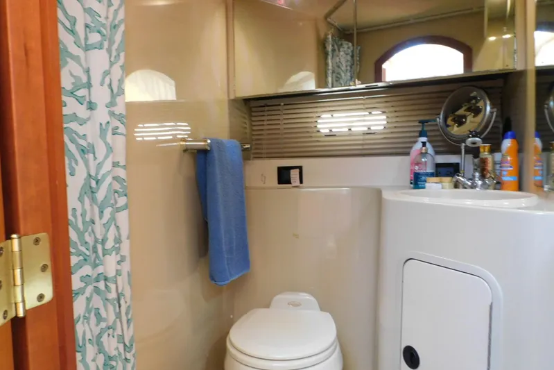How Lucky Yacht Photos Pics Bathroom interior of 2003 Cruisers Yachts 3750 Motoryacht with sink, toilet, and shower curtain.