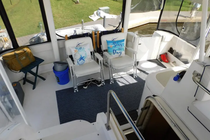 How Lucky Yacht Photos Pics 2003 Cruisers Yachts 3750 Motoryacht interior with chairs, nautical decor, and dockside view.