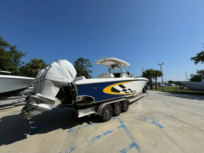  Yacht Photos Pics 2009 Fountain 38 CC Tournament Edition boat on trailer, blue and yellow design, sunny day.