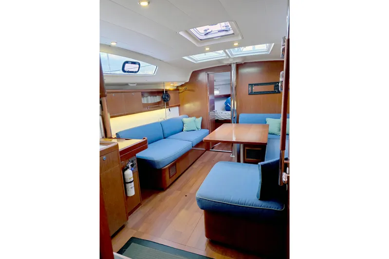 Unfettered Yacht Photos Pics Interior of 2011 Beneteau 40 sailboat with blue seating and wooden finishes.