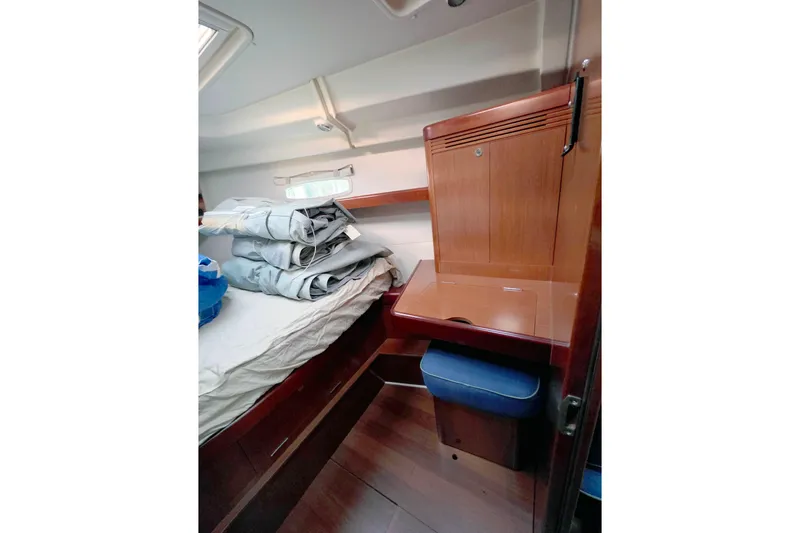 Unfettered Yacht Photos Pics Cozy cabin interior of 2011 Beneteau 40 sailboat with wooden furnishings and bedding.