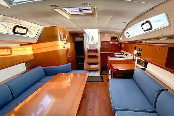 Unfettered Yacht Photos Pics Interior of 2011 Beneteau Oceanis 40 sailboat with wood finish and blue seating.