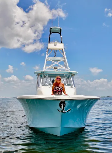 Saltwater Striker Yacht Photos Pics 2016 SeaVee 430 Fish Around boat on water, clear sky, person seated at bow.