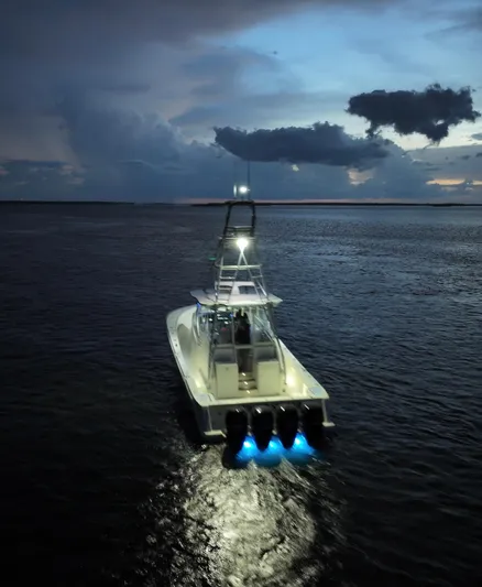 Saltwater Striker Yacht Photos Pics 2016 SeaVee 430 Fish Around boat illuminated on calm waters at dusk.
