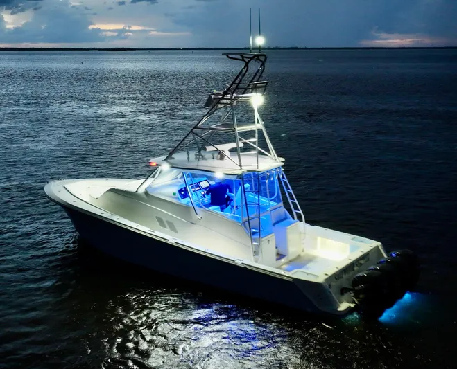 Saltwater Striker Yacht Photos Pics 2016 SeaVee 430 Fish Around boat illuminated on calm waters at dusk.