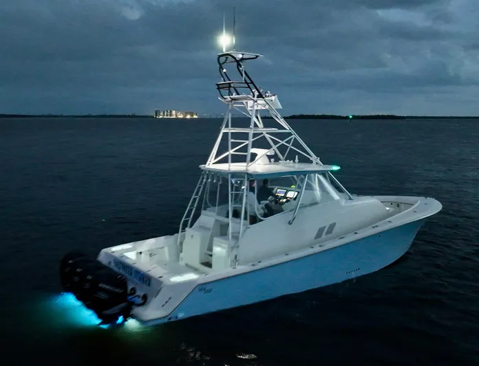 Saltwater Striker Yacht Photos Pics 2016 SeaVee 430 Fish Around boat illuminated on dark waters at dusk.