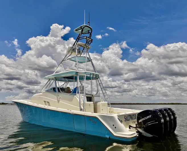 Saltwater Striker Yacht Photos Pics 2016 SeaVee 430 Fish Around boat with tower, on calm water under cloudy sky.