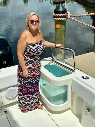 Saltwater Striker Yacht Photos Pics Woman on 2016 SeaVee 430 Fish Around boat, standing by livewell, docked at marina.