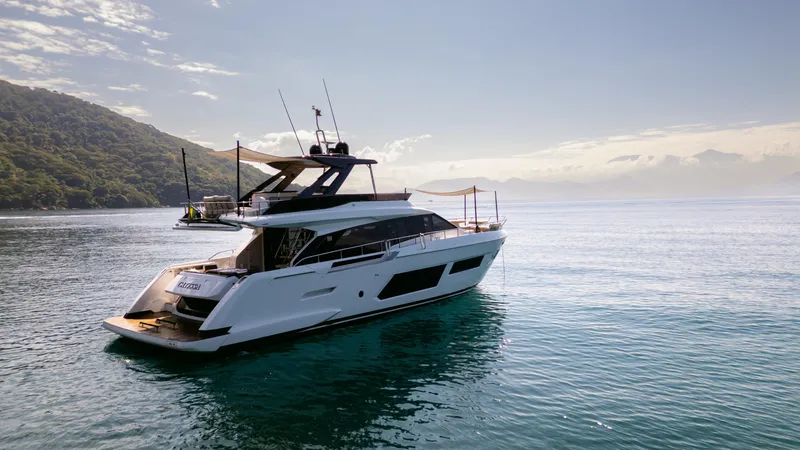 Catissa Yacht Photos Pics Luxurious 2024 Ferretti Yachts 670 cruising on serene waters, with scenic mountain backdrop.