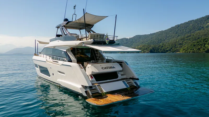 Catissa Yacht Photos Pics 2024 Ferretti Yachts 670 cruising on serene waters near lush green hills.