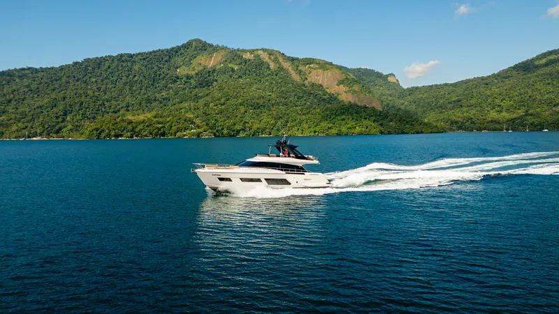 Catissa Yacht Photos Pics 2024 Ferretti Yachts 670 cruising on a serene blue sea with lush green hills.