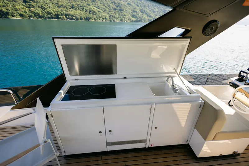 Catissa Yacht Photos Pics Outdoor kitchen on 2024 Ferretti Yachts 670, featuring stove and sink, overlooking serene waters.
