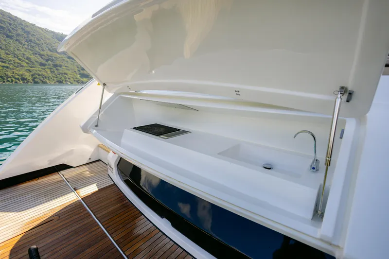 Catissa Yacht Photos Pics Outdoor kitchenette on 2024 Ferretti Yachts 670, featuring sink and grill, with scenic water view.