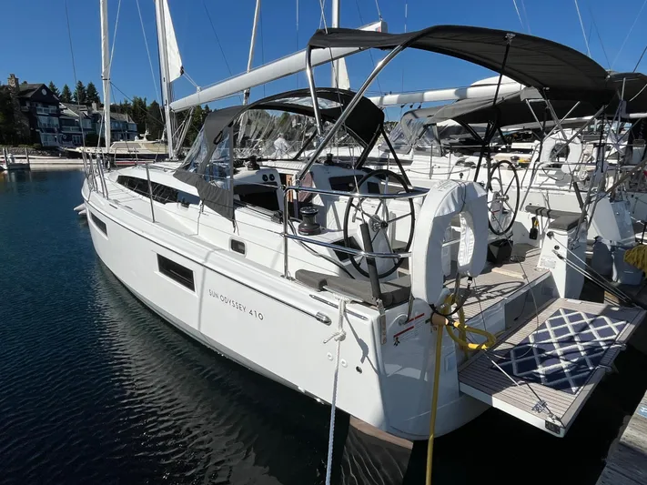  Yacht Photos Pics 2024 Jeanneau Sun Odyssey 410 sailboat docked in marina, featuring sleek design and modern amenities.
