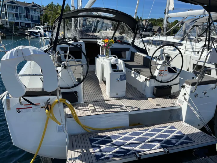  Yacht Photos Pics 2024 Jeanneau Sun Odyssey 410 sailboat with dual steering wheels, docked in a marina.