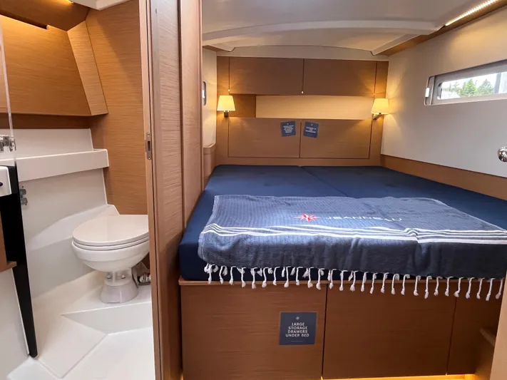  Yacht Photos Pics 2024 Jeanneau Sun Odyssey 410 cabin interior with bed, bathroom, and modern lighting.
