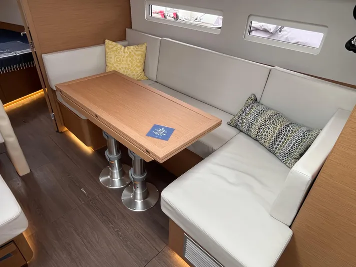  Yacht Photos Pics 2024 Jeanneau Sun Odyssey 410 interior with modern seating and wooden table.