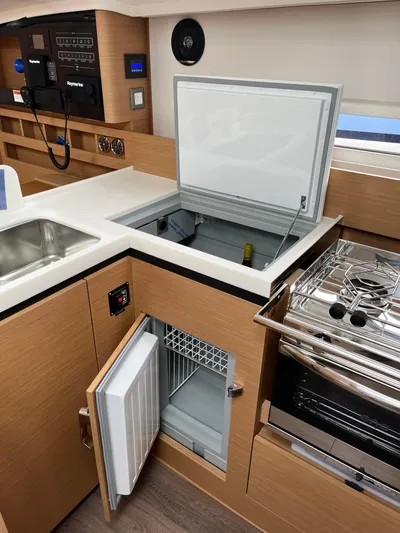  Yacht Photos Pics 2024 Jeanneau Sun Odyssey 410 yacht kitchen with open fridge, freezer, and stove.