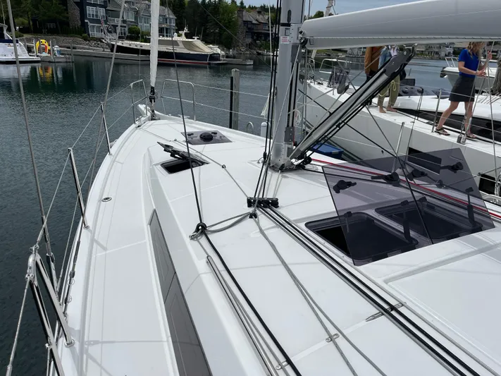  Yacht Photos Pics 2024 Jeanneau Sun Odyssey 410 sailboat docked in a marina, showcasing sleek deck design.