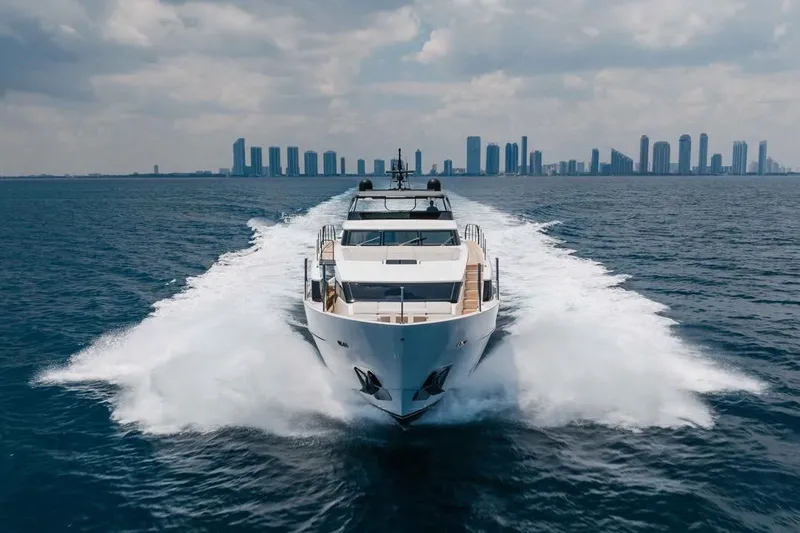 Chameleon Yacht Photos Pics 2024 Sanlorenzo SL90A yacht cruising on open water with city skyline backdrop.