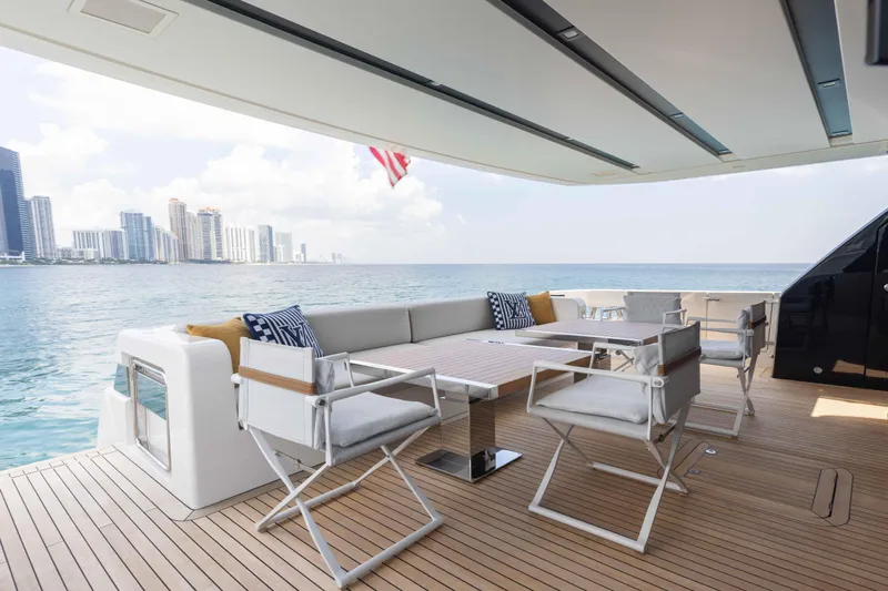 Chameleon Yacht Photos Pics Luxurious 2024 Sanlorenzo SL90A yacht deck with modern seating, ocean view, and city skyline.