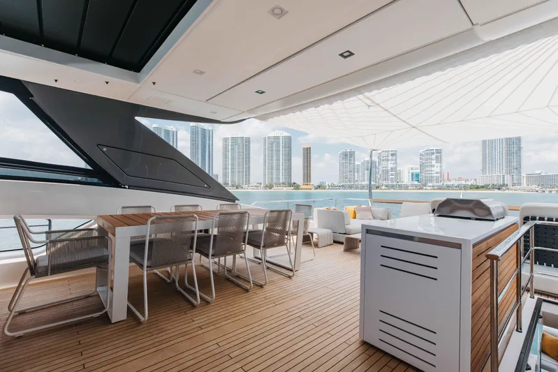 Chameleon Yacht Photos Pics Luxurious 2024 Sanlorenzo SL90A yacht deck with modern dining area and city skyline view.