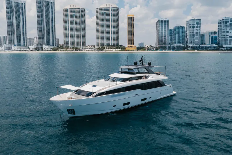 Chameleon Yacht Photos Pics 2024 Sanlorenzo SL90A yacht cruising near a city skyline on a sunny day.