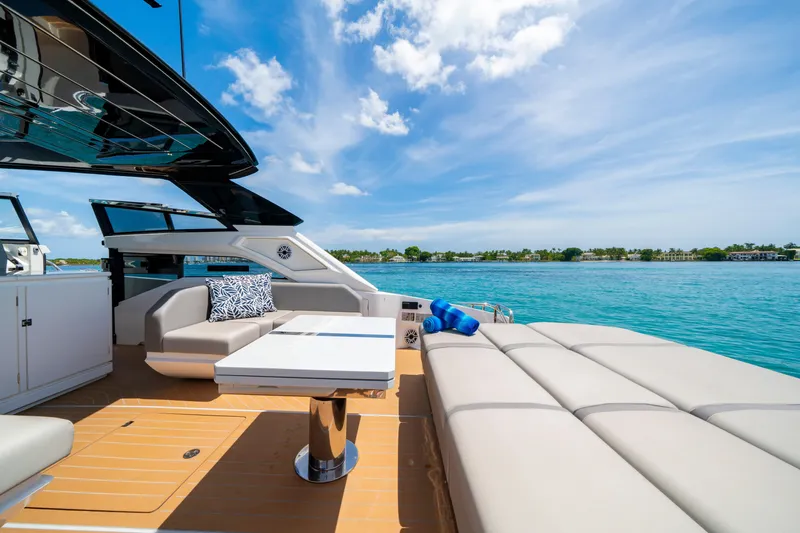  Yacht Photos Pics Luxurious 2024 Sunseeker Superhawk 55 yacht deck with seating, table, and ocean view.