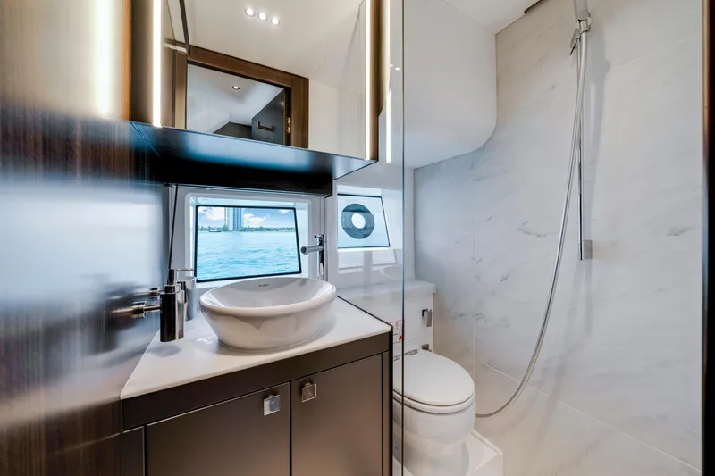  Yacht Photos Pics Luxurious bathroom in 2024 Sunseeker Superhawk 55 yacht, featuring modern fixtures and ocean view.