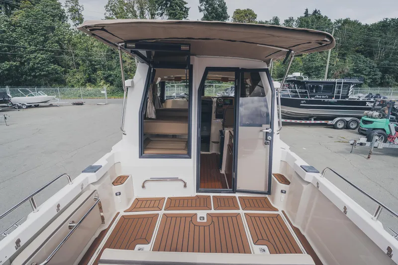  Yacht Photos Pics 2025 Ranger Tugs R-23 boat with open cabin, teak deck, and canopy in a marina setting.