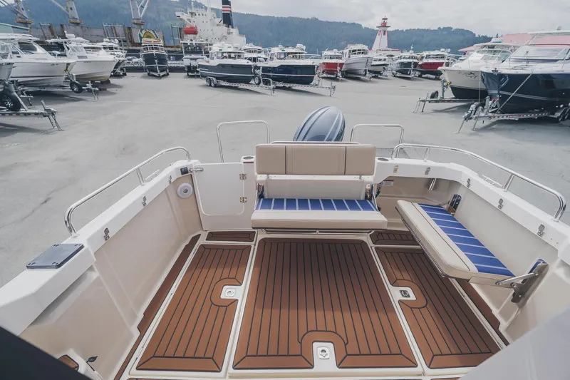  Yacht Photos Pics 2025 Ranger Tugs R-23 boat interior with seating and wood-style flooring at a marina.