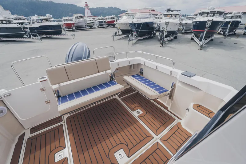  Yacht Photos Pics 2025 Ranger Tugs R-23 boat interior with seating, docked among other boats.