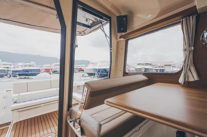  Yacht Photos Pics Interior of 2025 Ranger Tugs R-23 boat with wooden table and marina view.