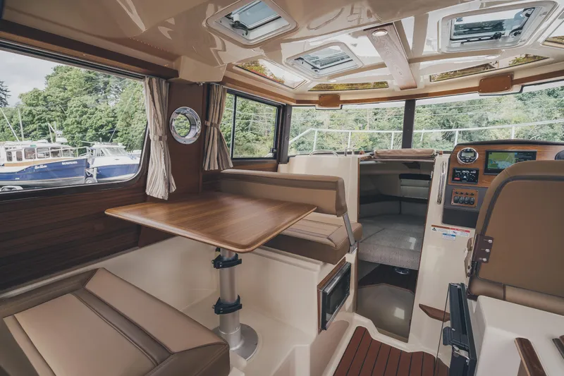  Yacht Photos Pics Interior of 2025 Ranger Tugs R-23 boat with wood accents and seating area.