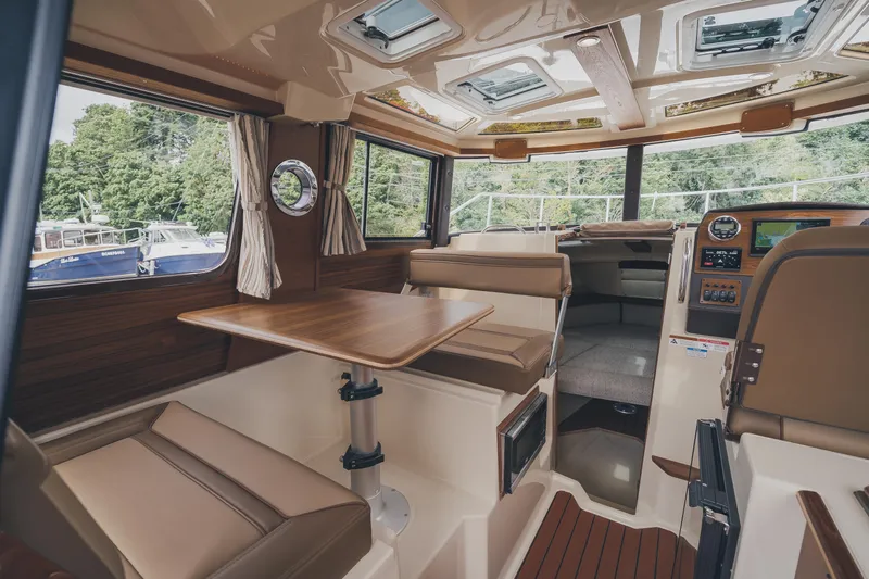  Yacht Photos Pics 2025 Ranger Tugs R-23 interior with seating, table, and navigation equipment.