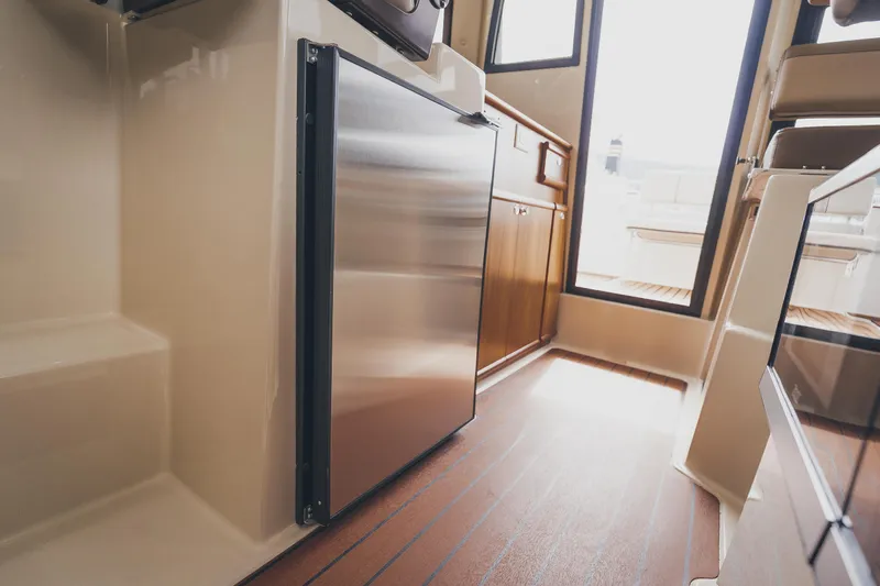  Yacht Photos Pics Interior of 2025 Ranger Tugs R-23, featuring a compact kitchen area with stainless steel appliances.