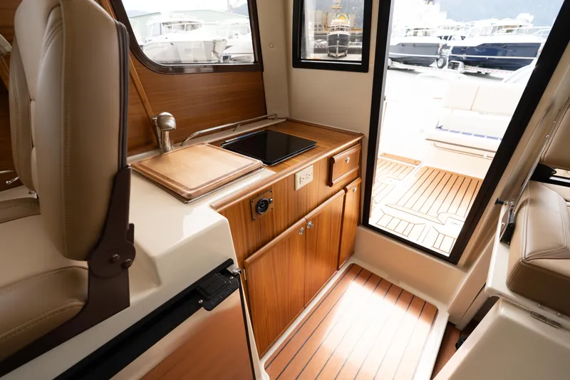  Yacht Photos Pics Interior of 2025 Ranger Tugs R-23 boat with wooden cabinetry and compact kitchen area.