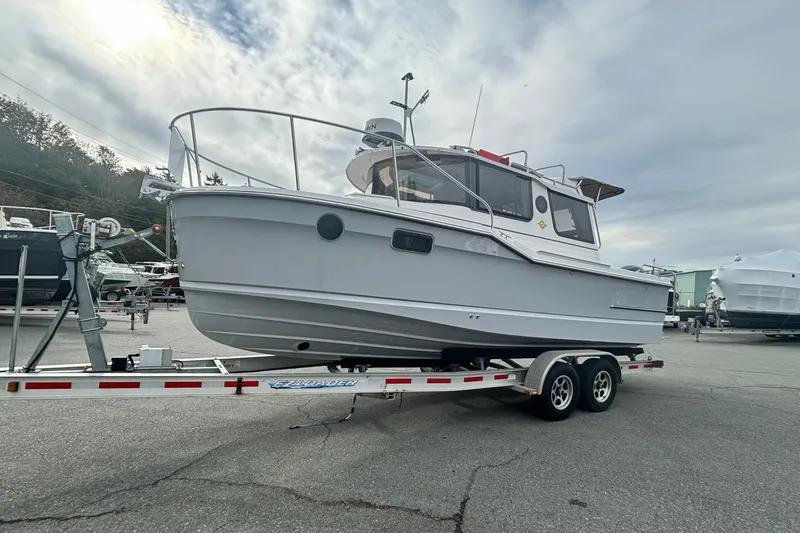  Yacht Photos Pics 2025 Ranger Tugs R-23 boat on trailer, parked outdoors under cloudy sky.