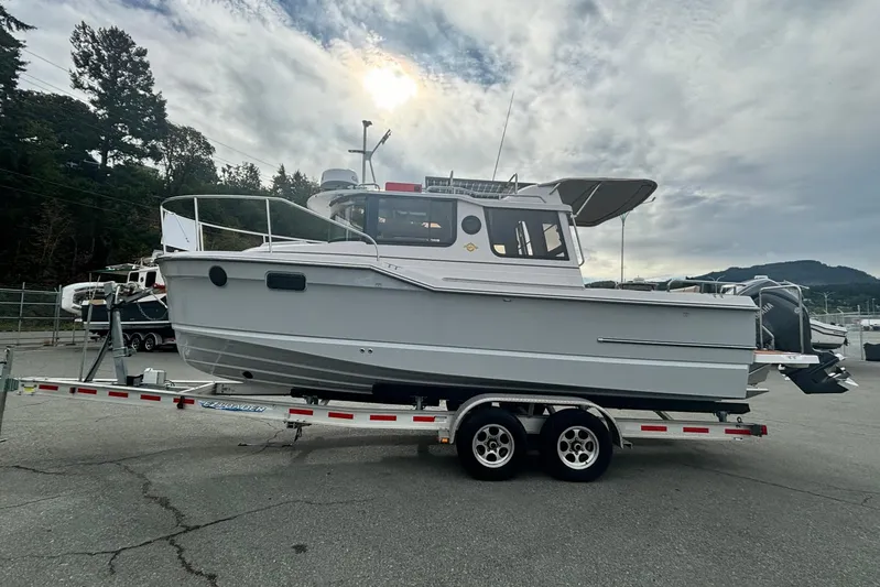  Yacht Photos Pics 2025 Ranger Tugs R-23 boat on trailer, parked outdoors under cloudy sky.