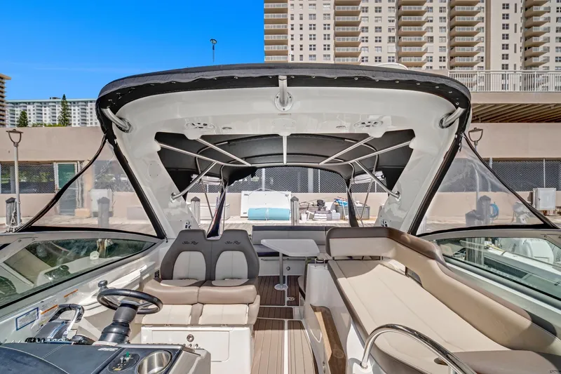  Yacht Photos Pics 2015 Sea Ray 350 Sundancer boat interior with seating and helm, docked near high-rise buildings.