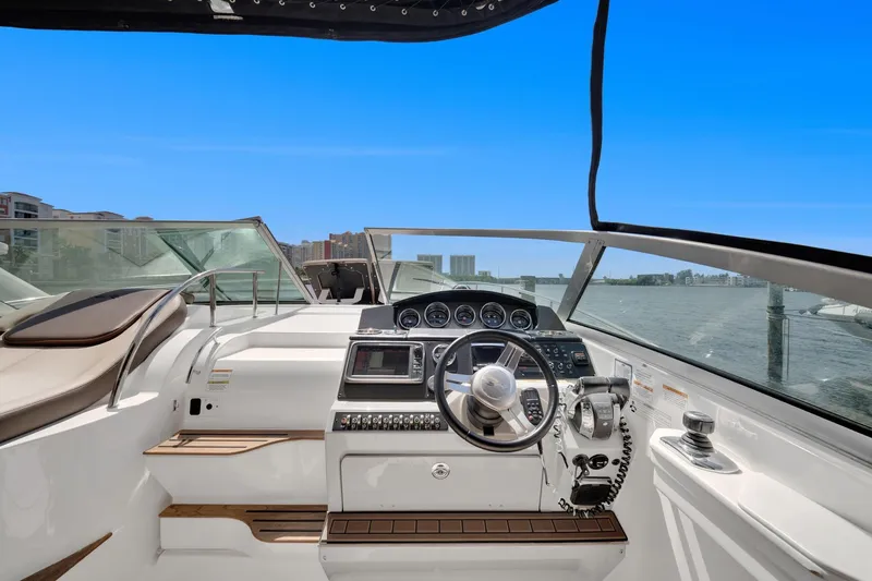  Yacht Photos Pics 2015 Sea Ray 350 Sundancer helm with modern controls, overlooking a serene waterfront.