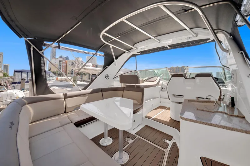  Yacht Photos Pics 2015 Sea Ray 350 Sundancer yacht interior with seating, table, and helm under canopy.