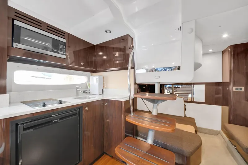  Yacht Photos Pics Luxurious interior of 2015 Sea Ray 350 Sundancer yacht with modern kitchen and seating area.