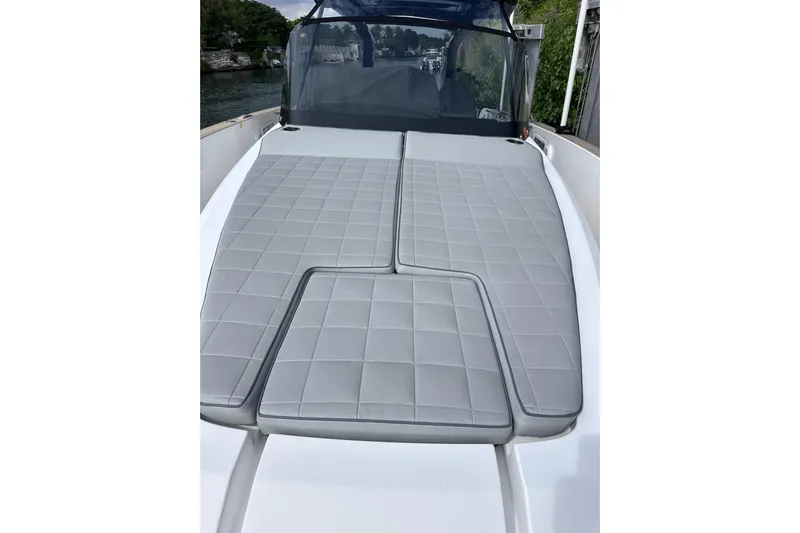 No Name Yacht Photos Pics 2024 Pardo Yachts P38 with sleek gray cushioned deck, docked by lush greenery.