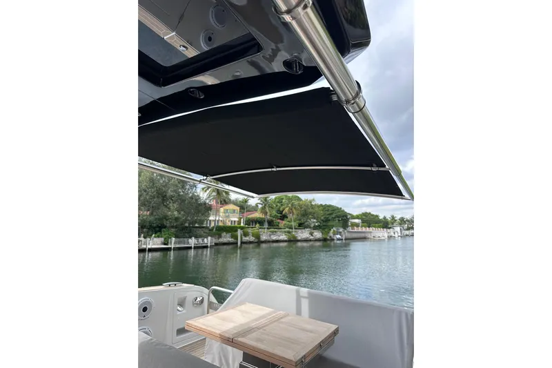 No Name Yacht Photos Pics 2024 Pardo Yachts P38 with canopy, docked by a scenic waterfront.