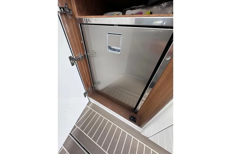 No Name Yacht Photos Pics Stainless steel refrigerator in 2024 Pardo Yachts P38 interior, featuring wooden cabinetry.