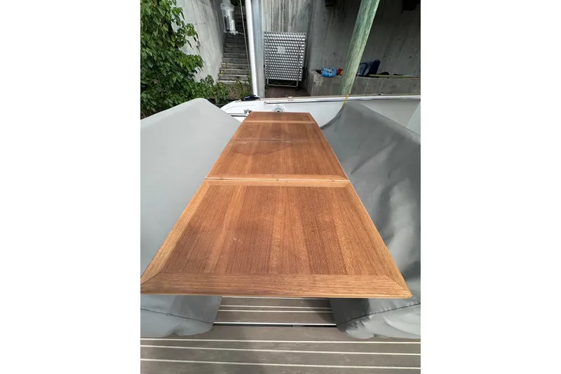No Name Yacht Photos Pics 2024 Pardo Yachts P38 wooden deck table, sleek design, outdoor setting.