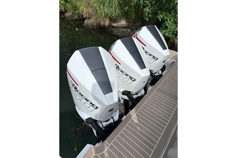 No Name Yacht Photos Pics Triple outboard engines on 2024 Pardo Yachts P38, docked near lush greenery.
